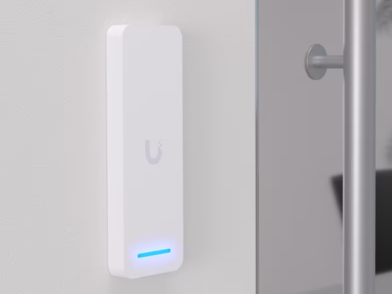 Card reader mounted beside a commercial glass entry door